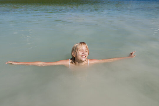 Little girl enjoys bathing in the lake