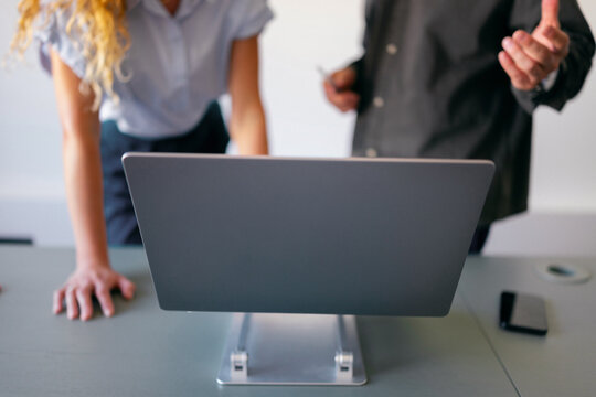 Two People Collaborating Over Laptop in Office