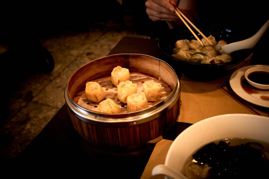 Steamed Soup Dumplings Served on a Table With a Bowl of Noodles