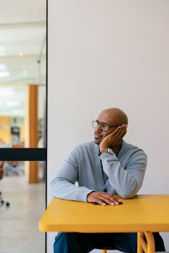 Thoughtful Businessman Sitting At Office Desk