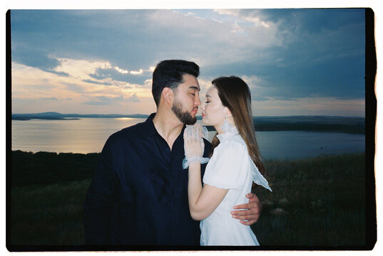 Romantic Couple Sharing an Intimate Moment by the Lake at Sunset