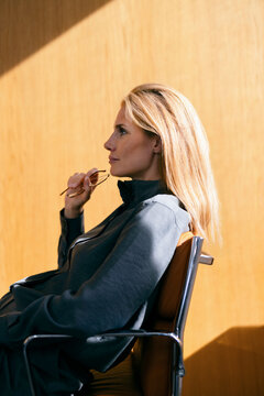 Contemplative Businesswoman Seated in Modern Office Chair