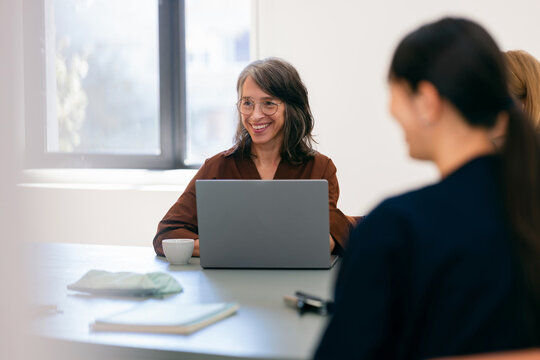 Smiling Businesswoman Working on Laptop During Office Meeting