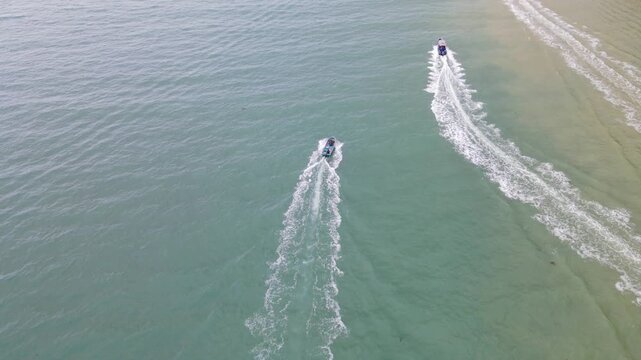 Aerial View of Blue Boats Racing Across Water