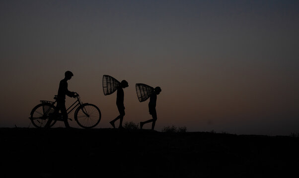 Golden hour silhouette of workers going home