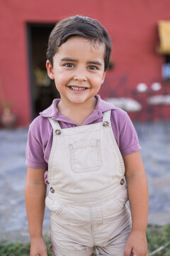 Portrait of a cute little boy standing on home porch
