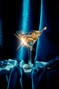 Elegant Martini Cocktail with Olives Against Soft Blue Backdrop