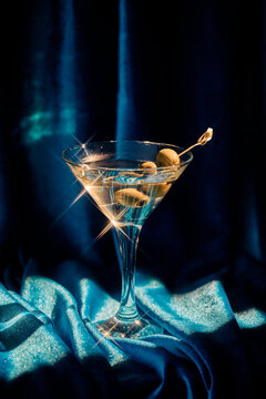 Elegant Martini Cocktail with Olives Against Soft Blue Backdrop