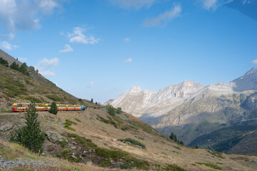 Fototapeta premium Petit Train d'Artouste moving through majestic Pyrenees mountain landscape under clear blue sky in France