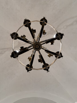 Ornate metal chandelier viewed from below, decorative wheel pattern ceiling fixture