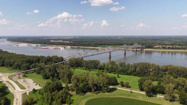 Aerial of truss bridge crossing the Mississippi River in Cairo Illinois with active freight trains in rural landscape on Missouri border