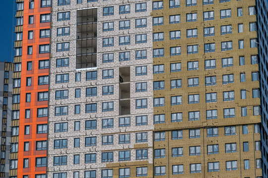 Modern urban architecture showcases vibrant colors and unique designs in a residential building under construction during a sunny day