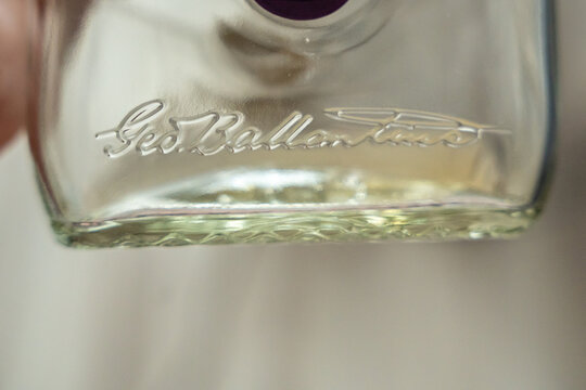 Warsaw, Poland - Sep 5, 2026: Close up of an embossed Ballantines logo on the bottom of a clear glass bottle indoors