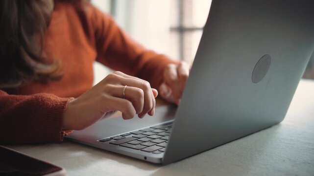 Close-up of an anonymous woman&rsquo;s hands typing on a laptop, highlighting digital work, productivity, technology, and modern professional life.
