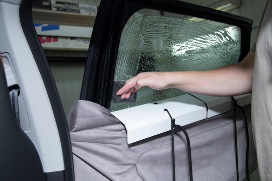 Car window tinting. Tinting a car without removing the door trim using special brackets. Car window film.