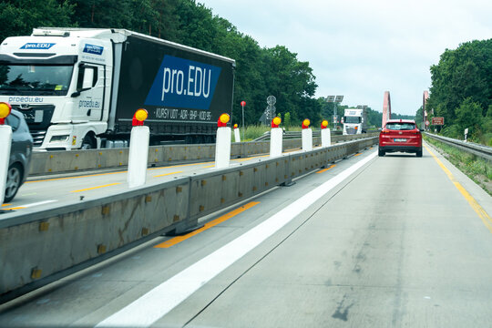 Germany - Aug 22, 2026: Truck driving past concrete barriers in a narrowed lane on a German autobahn construction zone