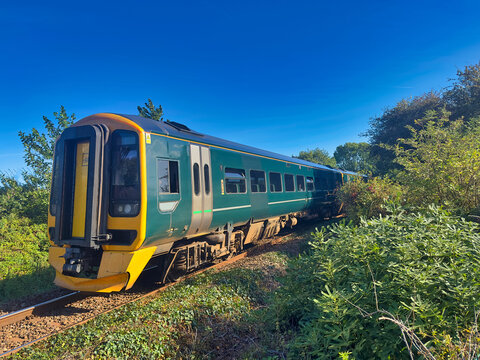 Passenger Train Travelling Through the Countryside on a Sunny Day