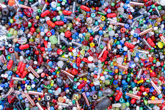 Full frame background of mixed colorful glass seed beads and bugle beads for handmade jewelry.