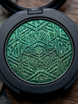 Compact press dark green shimmer eyeshadow with geometric pattern detail