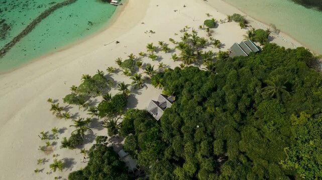 Aerial drone view of Inaladelan Island in Port Barton, Palawan, Philippines, featuring a white sand beach and crystal-clear tropical waters.