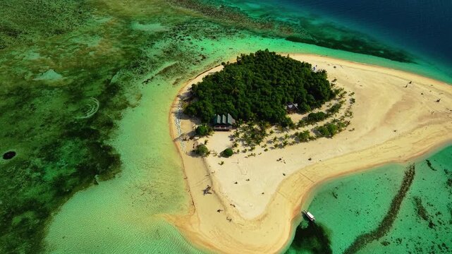Aerial drone footage of Inaladelan Island in Port Barton, San Vicente, Palawan, Philippines, showcasing its white sand beach, crystal-clear turquoise waters and lush tropical landscape.