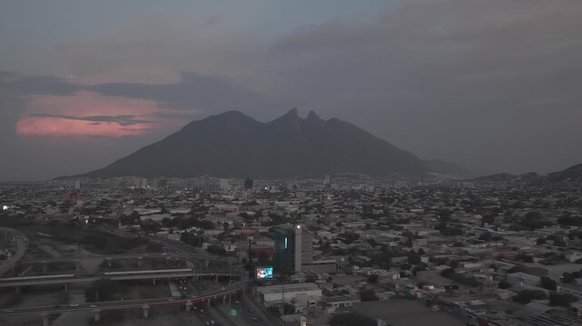 Aerial lateral tracking shot over the Santa Catarina River toward the Cerro de la Silla in Monterrey at sunset, Nuevo Le&oacute;n. D-Log M