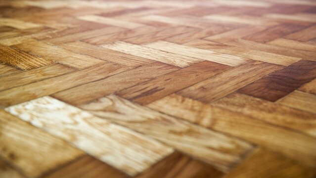 Light oak herringbone wood parquet flooring texture background.
