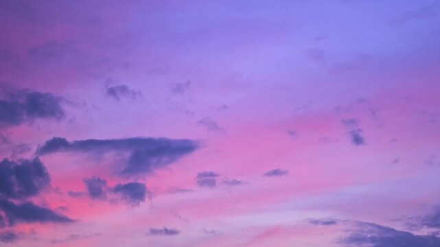 Morning or evening sky. Colorful clouds fill twilight with gradients of purple and pink during sunset or sunrise. Natural background. Beauty in nature. Expressive cloudscape. High quality 4K footage.