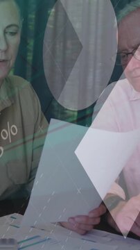 Animation of infographic interface over senior caucasian couple analyzing expenses