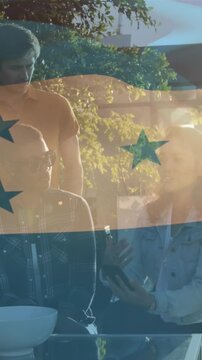 Composite video of waving honduras flag against group of diverse colleagues discussing at a cafe