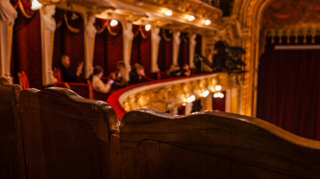 Elegant theater interior with ornate golden balconies and red velvet curtains
