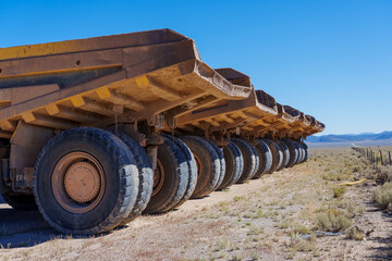 Giant heavy duty Dump Trucks commonly used in mining parked in a row in the Nevada desert © gchapel