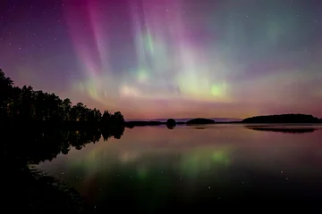 Northern lights dancing over lake in Farnebofjarden national park in north of sweden © Conny Sjostrom