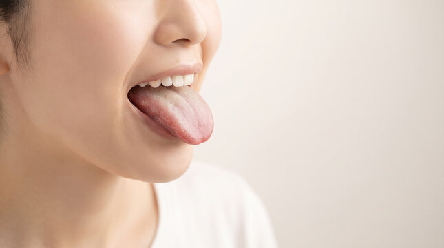 舌を出して健康状態や舌苔を確認する女性の口元