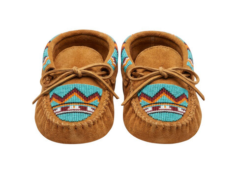 Pair of brown suede baby moccasins with beaded patterns isolated on transparent background