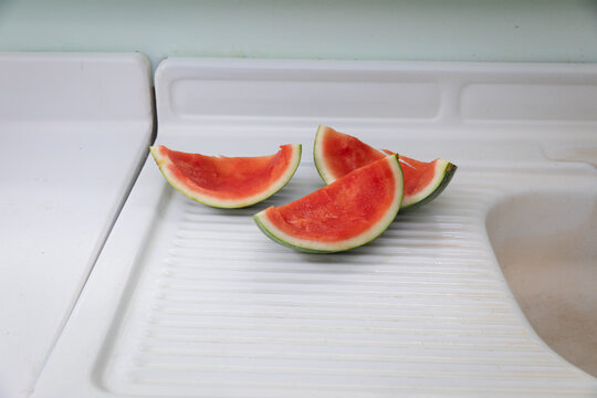 watermelon slices on white counter with rind