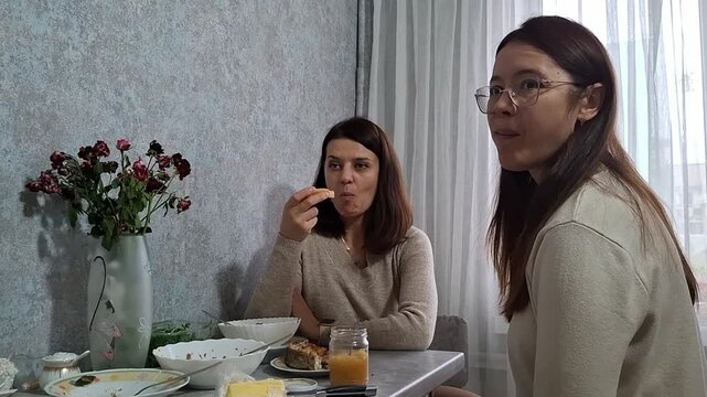 Friends share a meal and conversation in a modern kitchen setting