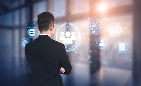Professional Businessman Analyzing Digital Interface with Icons Representing Collaboration, Strategy, and Innovation in Modern Workplace Setting. Entropy.