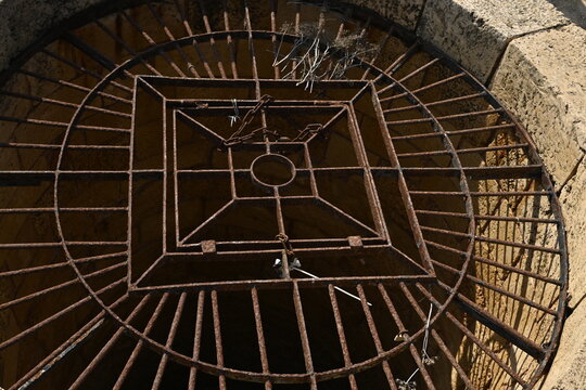 well, grate, Caesarea, archaeology, iron,Decorative iron grate covering ancient stone water well in Caesarea, Geometric iron metal grid on historic underground cistern opening