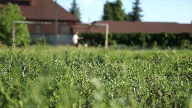 Male foot of professional footballer shooting a penalty kicks on stadium at sunny summer day. Leg of sportsman kicking ball at green field. Young man training at meadow. Concept of freestyle football