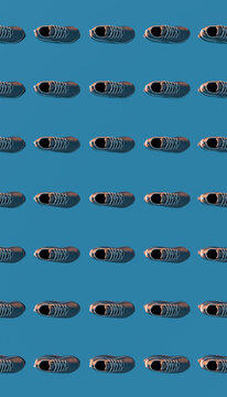 Running shoes arranged in a repetitive pattern on blue background