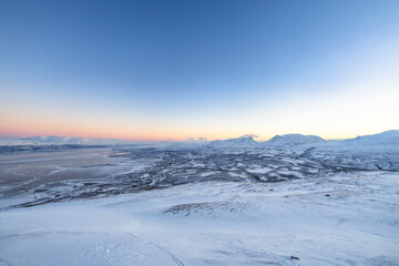 Obraz premium Winter panorama of Lake Tornetrask and snowy mountains in Abisko National Park, Sweden