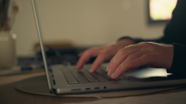 Female hands working on laptop computer at desk, modern remote work and productivity concept in warm light, 4K