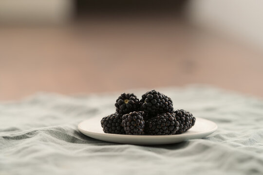 fresh ripe blackberry on a white saucer