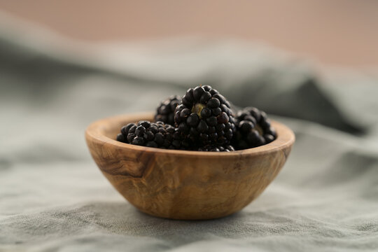 fresh ripe blackberry in a small wooden bowl