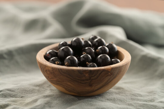ripe blackcurrant in wood ceramic bowl