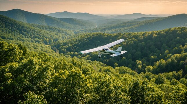 Small airplane flies over lush green mountain range during daytime. The aircraft soars above dense forest and rolling hills under a soft sky.