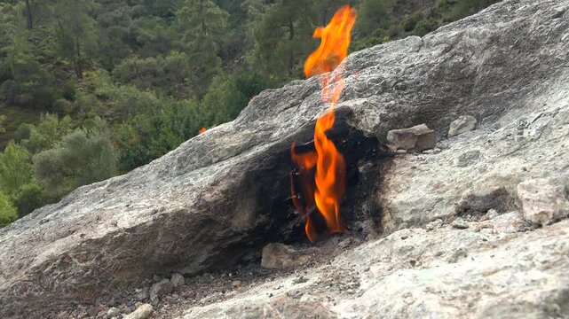 Yanartas methane flames burn through rocky vents at Cirali Antalya Turkey as eternal fire. Natural gas seepage creates burning stone phenomenon with fumarole heat and geology.