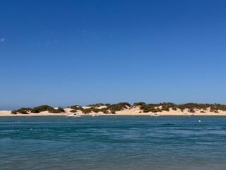 view from the Playa de Sancti Petri over the Cano de Sancti Petri with boats and buoys to the dunes of Playa de Camposoto, vacation, Chiclana de la Frontera, Cadiz, Andalusia, Spain © keBu.Medien
