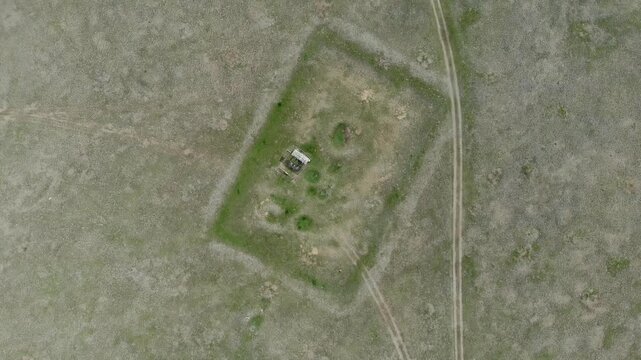 Ongi burial complex in Mongolia shows ancient stone circles and central ceremonial structure. Early civilization monument forms prehistoric ritual site across dry steppe archaeology terrain.